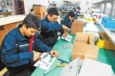 員工在生產(chǎn)車(chē)間裝配工業(yè)產(chǎn)品